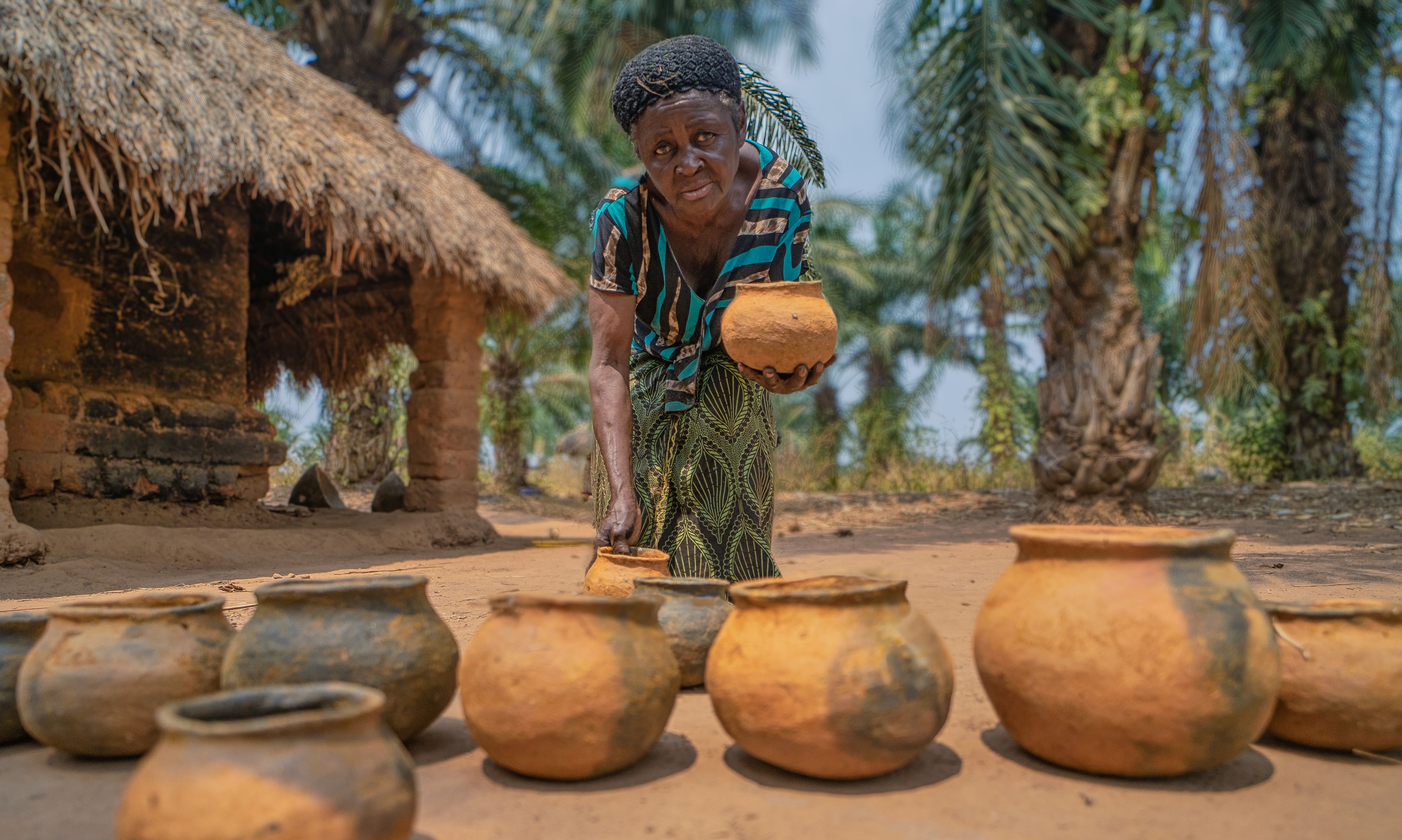 woman showing terracotta pots congo